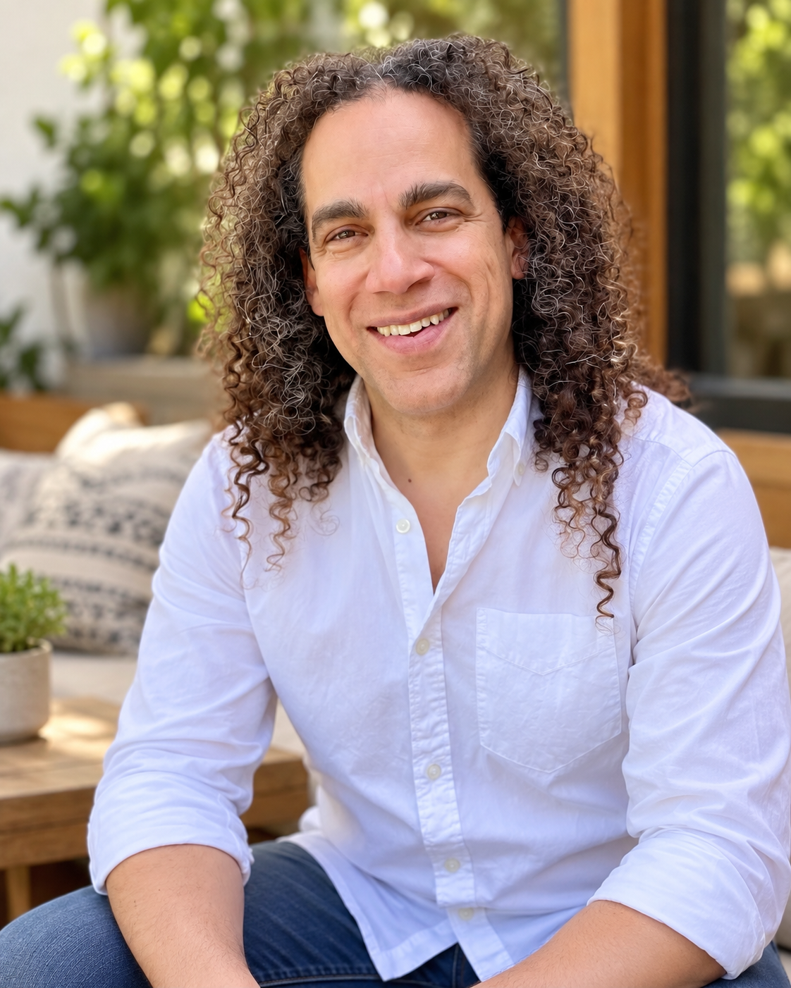 Adrian Williams smiling outdoors in a white shirt